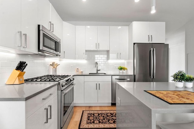 kitchen featuring stainless steel appliances, sink, and white cabinets