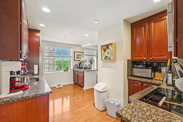 20 Chapel St Unit B811, Brookline, MA 02446 - kitchen featuring light wood-type flooring, recessed lighting, baseboards, dark stone counters, and backsplash