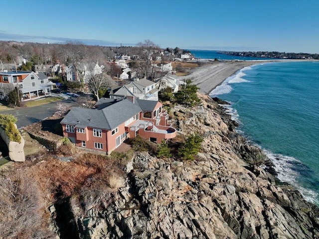 birds eye view of property with a water view and a beach view