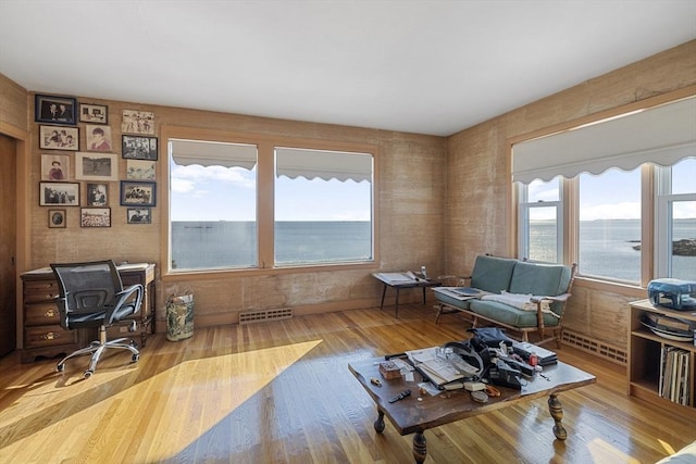 interior space with a water view, plenty of natural light, and light wood-type flooring