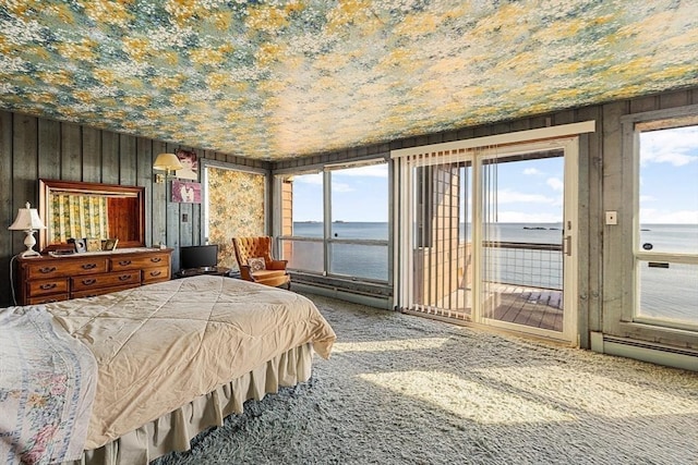 bedroom featuring access to exterior, carpet floors, and wood walls