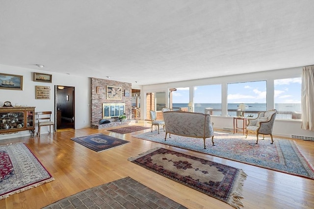 living room with a water view, a fireplace, and hardwood / wood-style floors