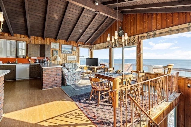 dining space featuring hardwood / wood-style floors, vaulted ceiling with beams, wooden walls, a notable chandelier, and wooden ceiling