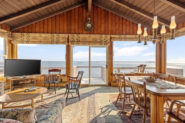 sunroom with a water view, a healthy amount of sunlight, and vaulted ceiling with beams