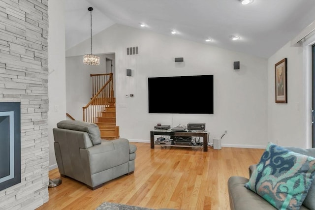 living area featuring visible vents, wood finished floors, stairs, high vaulted ceiling, and a notable chandelier