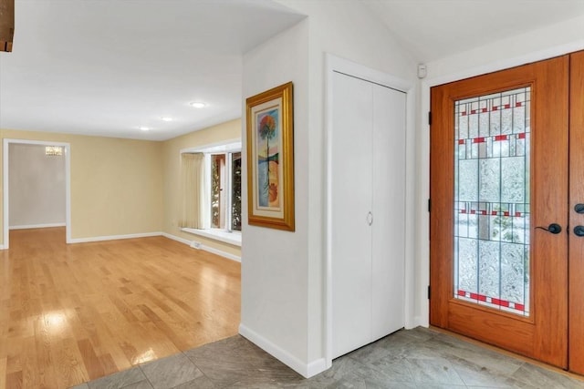 entryway featuring light wood finished floors, plenty of natural light, and baseboards