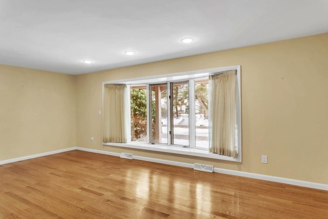 empty room featuring baseboards, recessed lighting, visible vents, and light wood-style floors