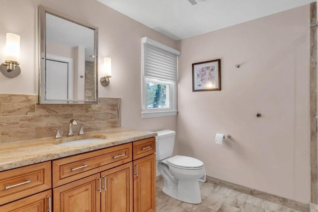 bathroom featuring toilet, vanity, and decorative backsplash