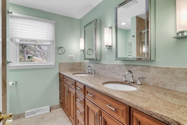 bathroom featuring double vanity, backsplash, a sink, and visible vents