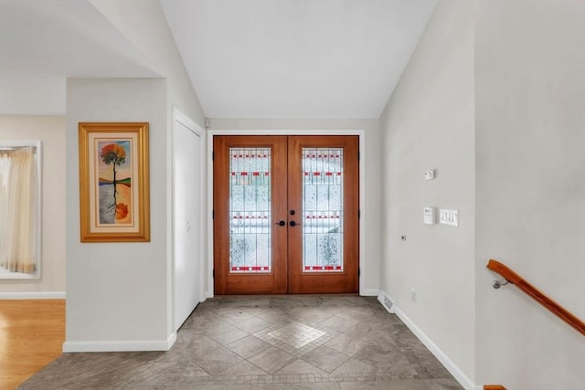 foyer entrance featuring visible vents, baseboards, vaulted ceiling, and french doors