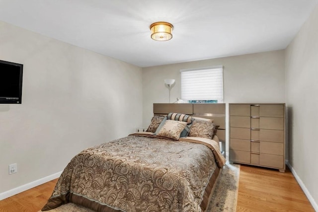 bedroom featuring baseboards and light wood finished floors