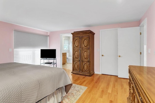 bedroom featuring light wood-style floors and connected bathroom