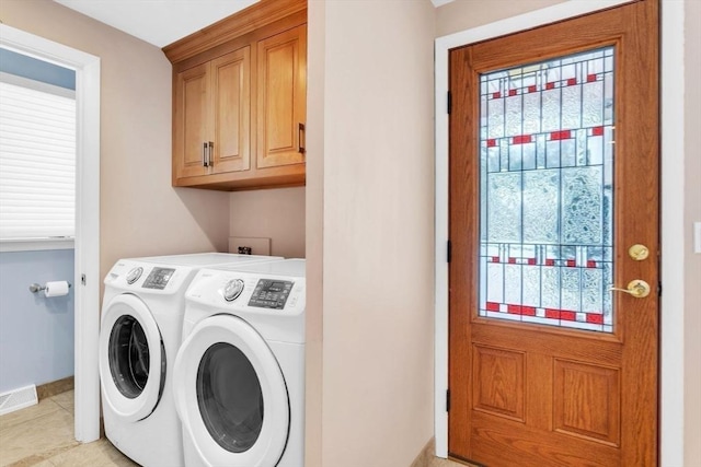 washroom featuring cabinet space, plenty of natural light, washing machine and clothes dryer, and visible vents