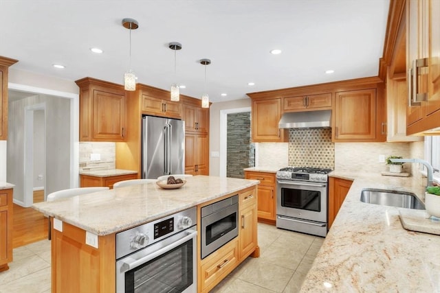 kitchen with hanging light fixtures, appliances with stainless steel finishes, extractor fan, and light stone counters