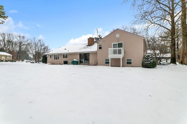 snow covered property featuring a chimney