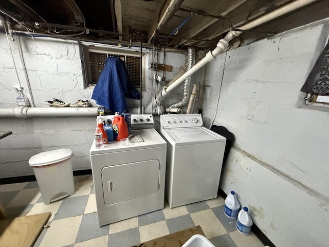 laundry area with light floors, laundry area, and washing machine and clothes dryer