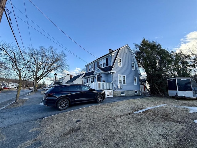 view of side of home with a gambrel roof