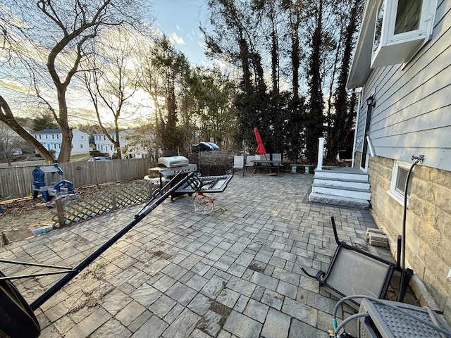 view of patio featuring a grill and fence