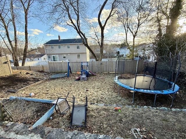 view of yard featuring a trampoline and fence