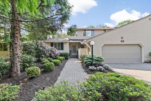 202 Allandale Rd Unit A, Boston, MA 02467 - view of front of house with stucco siding, driveway, and a garage
