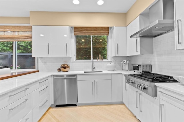 202 Allandale Rd Unit A, Boston, MA 02467 - kitchen with wall chimney exhaust hood, stainless steel appliances, a sink, white cabinets, and recessed lighting