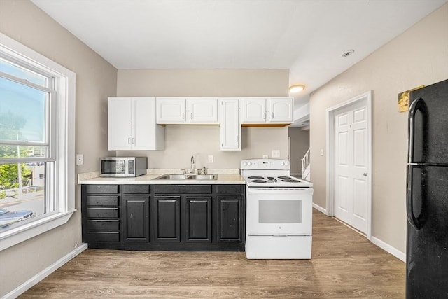 150 Belmont St, Worcester, MA 01605 - kitchen with white range with electric stovetop, a sink, freestanding refrigerator, stainless steel microwave, and white cabinets