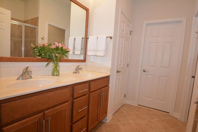 bathroom with tile patterned flooring, vanity, and a shower with door