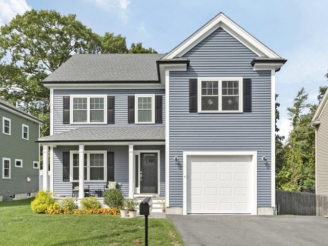 front facade featuring a porch, a front yard, and a garage