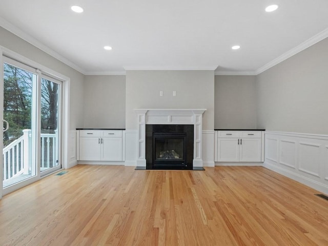 unfurnished living room featuring light hardwood / wood-style floors and ornamental molding