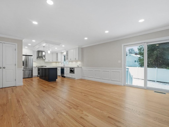 unfurnished living room featuring light wood-type flooring and ornamental molding