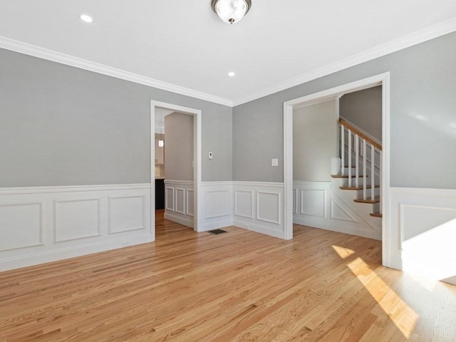 spare room featuring light hardwood / wood-style floors and crown molding