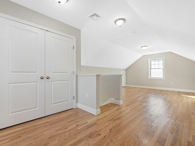 bonus room featuring light wood-type flooring and vaulted ceiling