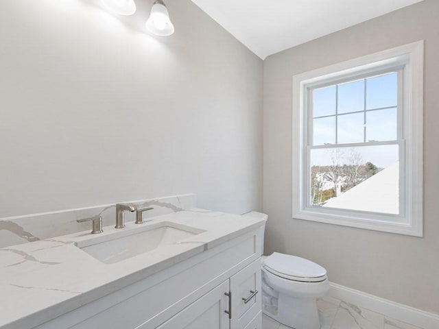 bathroom with vanity, toilet, and a wealth of natural light