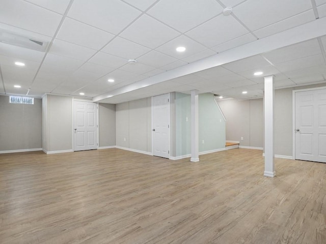 basement with light hardwood / wood-style floors and a drop ceiling