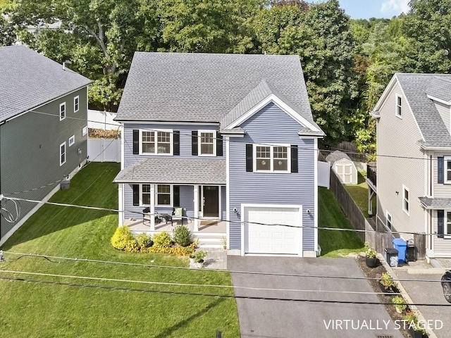 view of front of property with covered porch, a garage, and a front yard