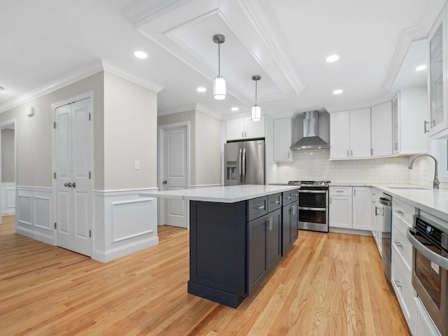 kitchen with pendant lighting, a center island, sink, wall chimney exhaust hood, and stainless steel appliances