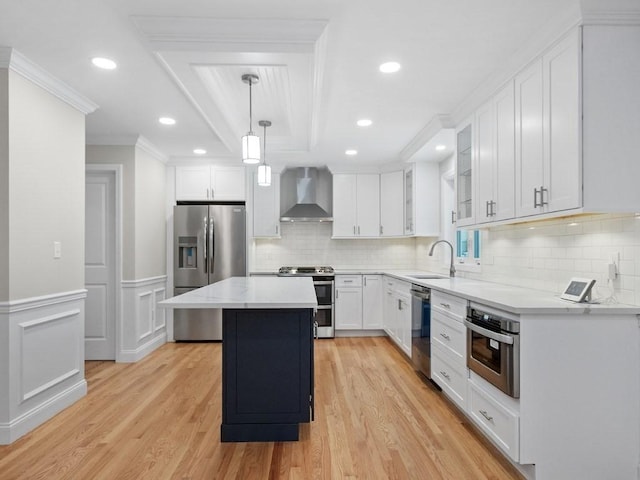 kitchen featuring a center island, stainless steel appliances, wall chimney range hood, and light hardwood / wood-style flooring