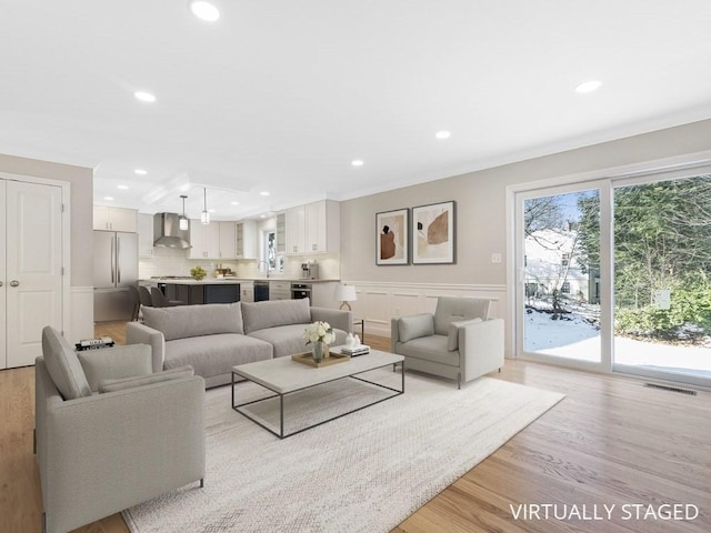 living room featuring light hardwood / wood-style flooring and ornamental molding