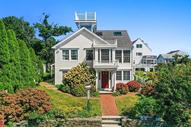 view of front of home featuring a balcony and a front lawn