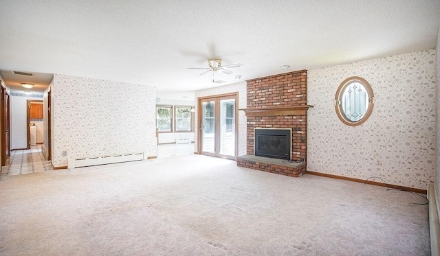 unfurnished living room with ceiling fan, a fireplace, a baseboard radiator, carpet flooring, and wallpapered walls