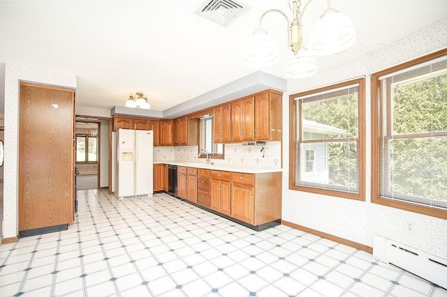 kitchen featuring white refrigerator with ice dispenser, visible vents, a chandelier, wallpapered walls, and a baseboard heating unit