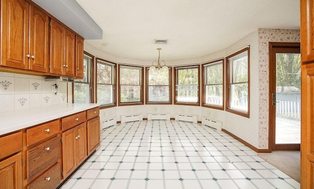kitchen featuring a baseboard heating unit, brown cabinets, and visible vents