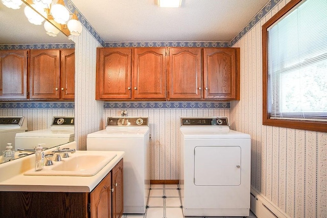 clothes washing area with cabinet space, separate washer and dryer, and wallpapered walls