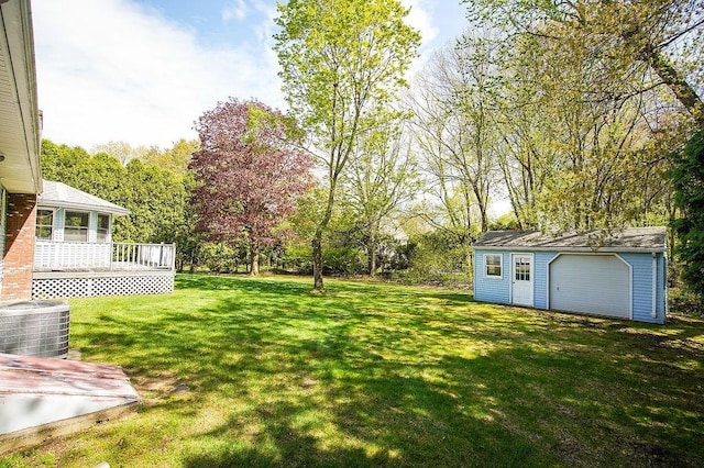 view of yard featuring a wooden deck, an outbuilding, a garage, central AC, and a storage unit