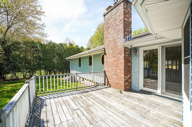 wooden terrace featuring a lawn