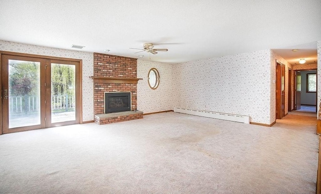 unfurnished living room with a baseboard radiator, carpet flooring, wallpapered walls, and a wealth of natural light