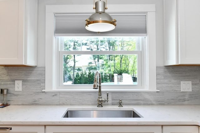 kitchen with a sink, backsplash, a healthy amount of sunlight, and white cabinets