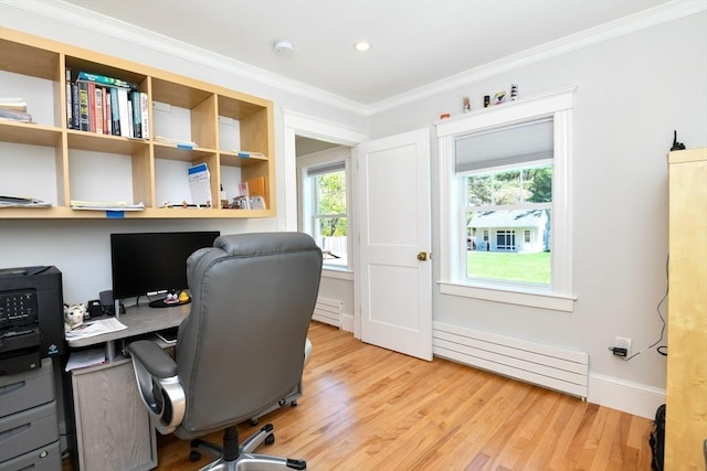 home office with crown molding, a baseboard radiator, a wealth of natural light, and light wood finished floors