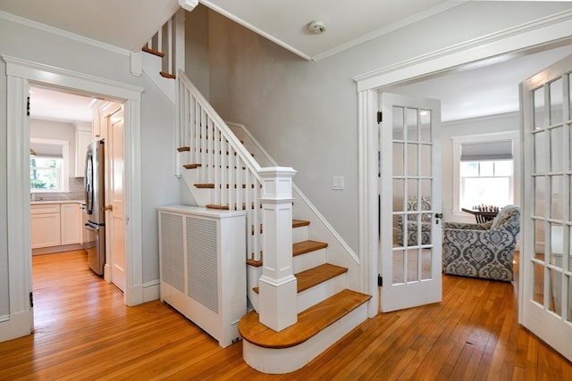 staircase with crown molding and hardwood / wood-style flooring