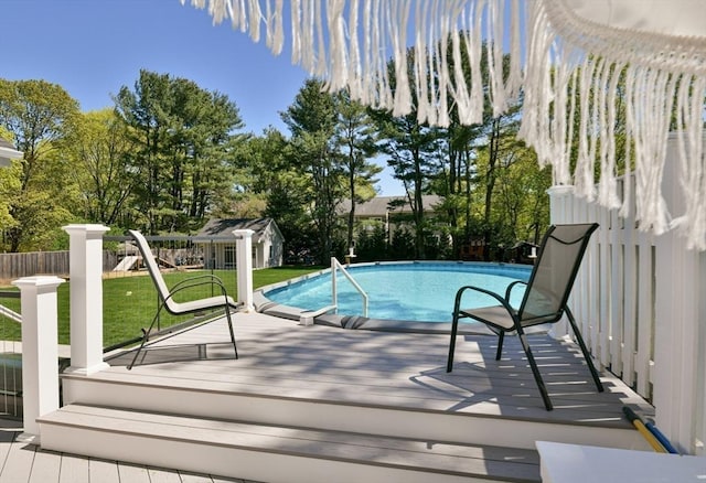 view of pool with a playground, fence, a wooden deck, a lawn, and a fenced in pool